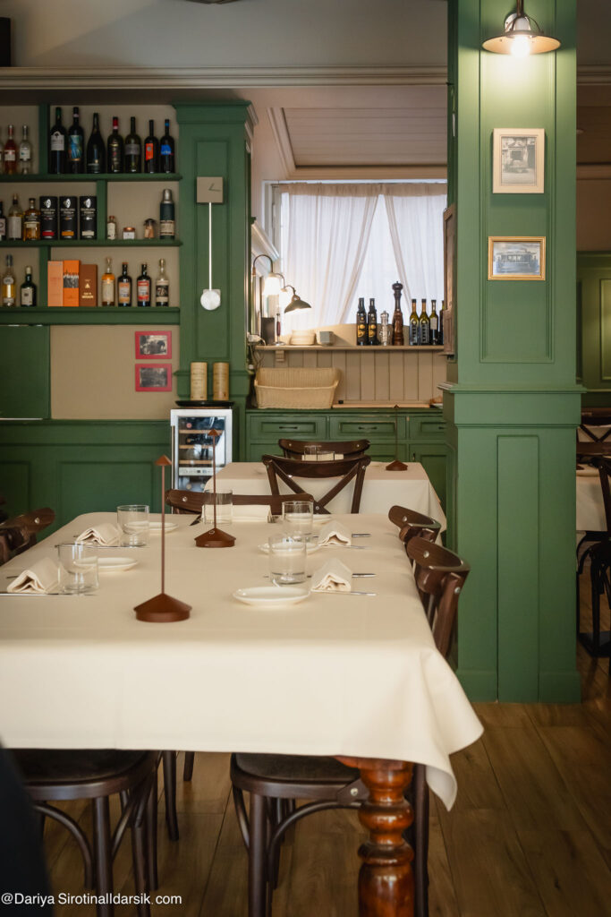 Накрытый к приходу гостей стол в ресторане Osteria Al GiGianca в Бергамо: белая скатерть, современная посуда.