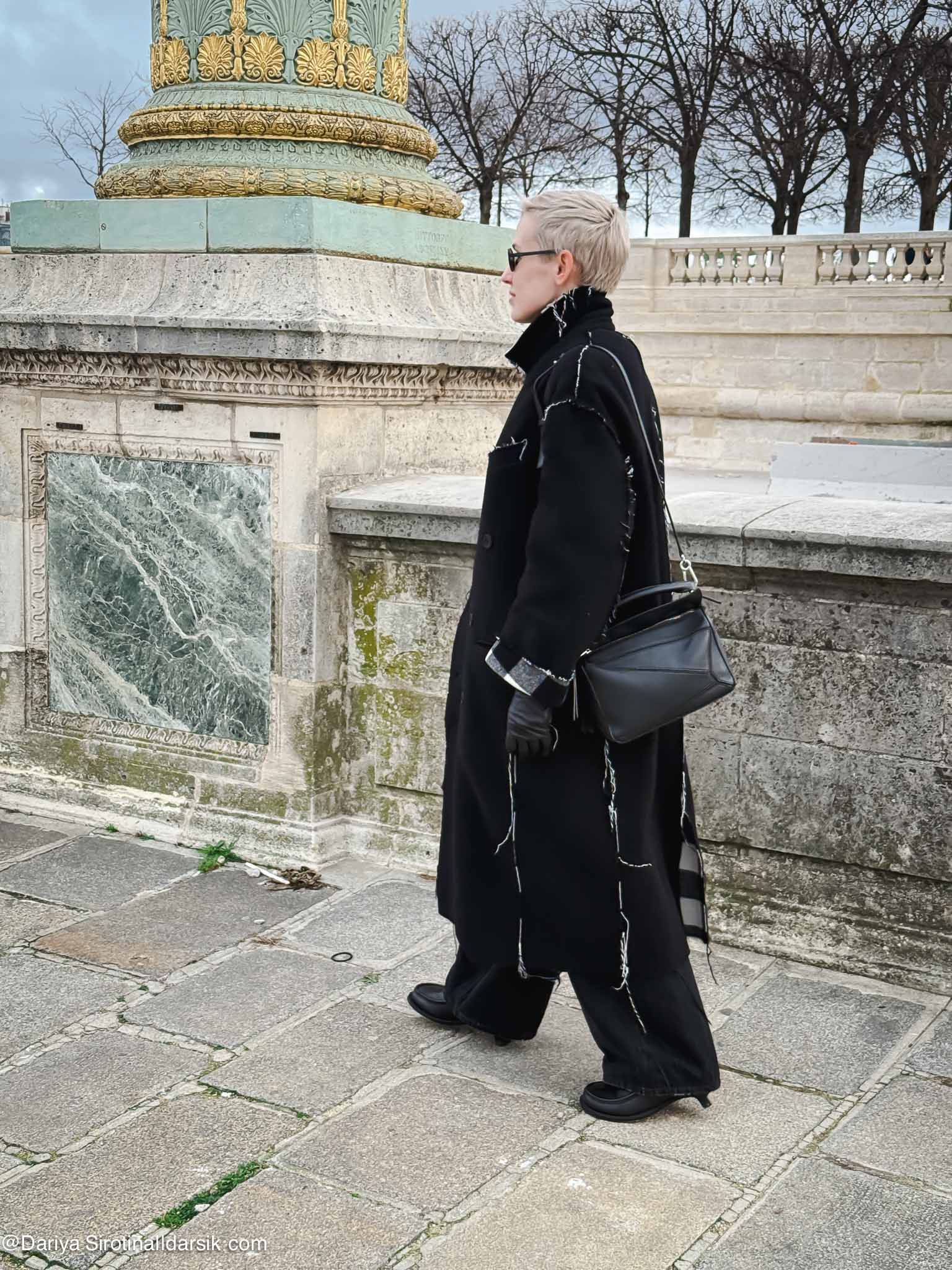 Парижский зимний образ: пальто Balenciaga, джинсы, лоферы Loewe со скошенным каблуком. Пример сочетания сдержанных цветов с интересной деталью.