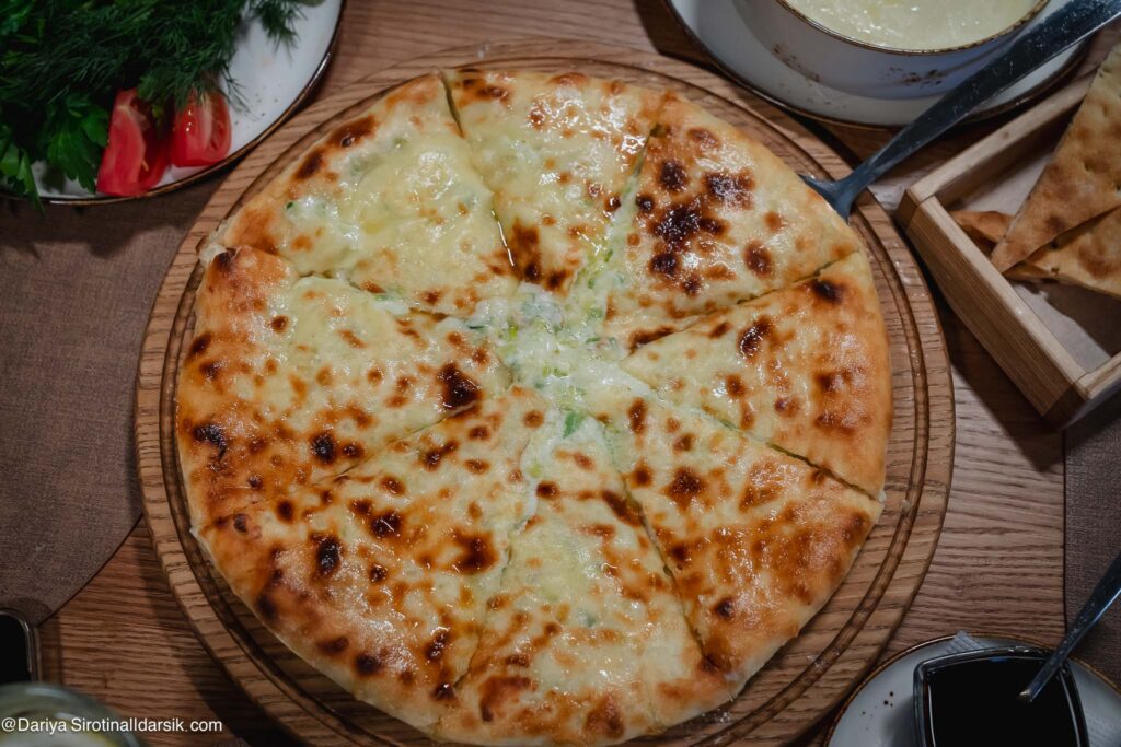 Осетинский пирог с черемшой — Цахараджин, зелёная начинка видна в разрезе